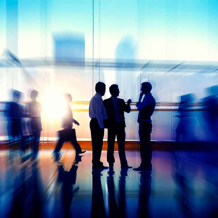 image of three men conversing in a hallway