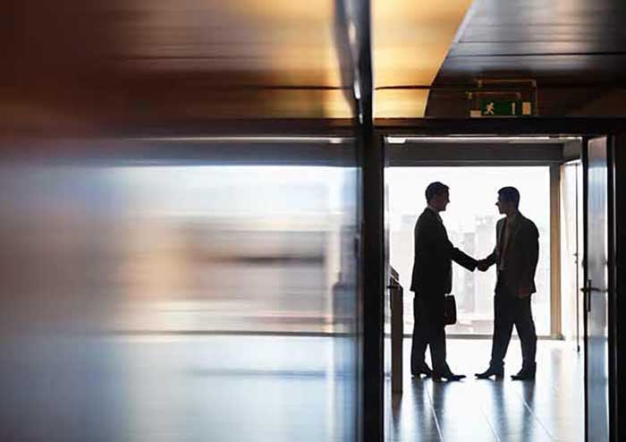 image of two men shaking hands in a hallway